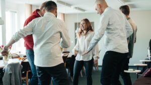 En grupp människor dansar i kontorsmiljö.