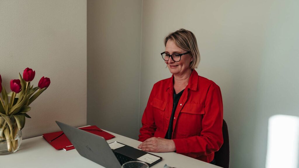 Kvinna i rött vid laptop
