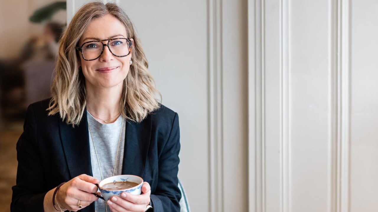 Porträttbild av Emma Vallin med en kaffekopp i handen