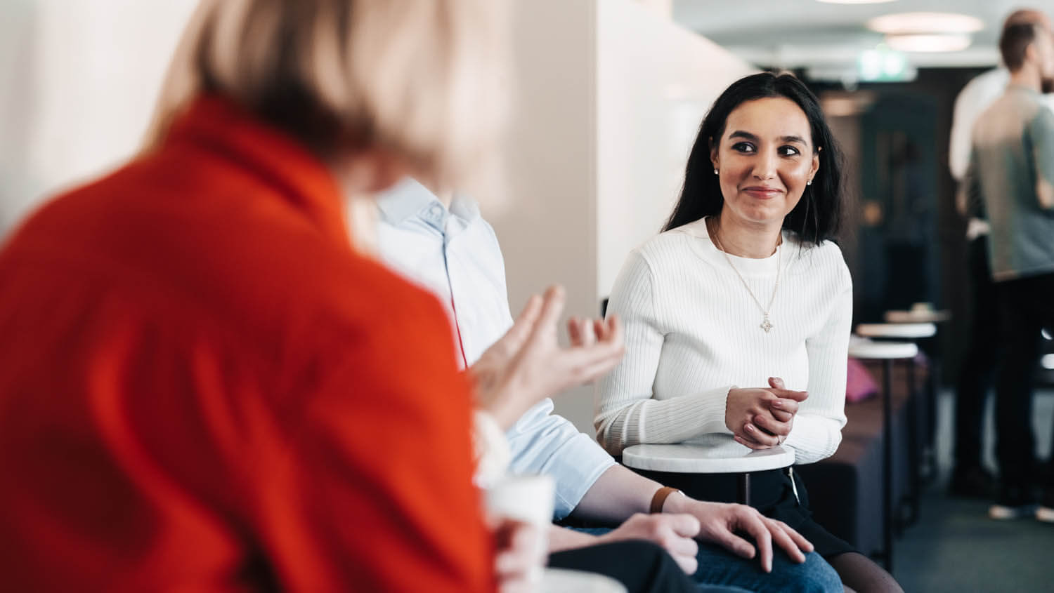 Personer samtalar i kontorsmiljö.
