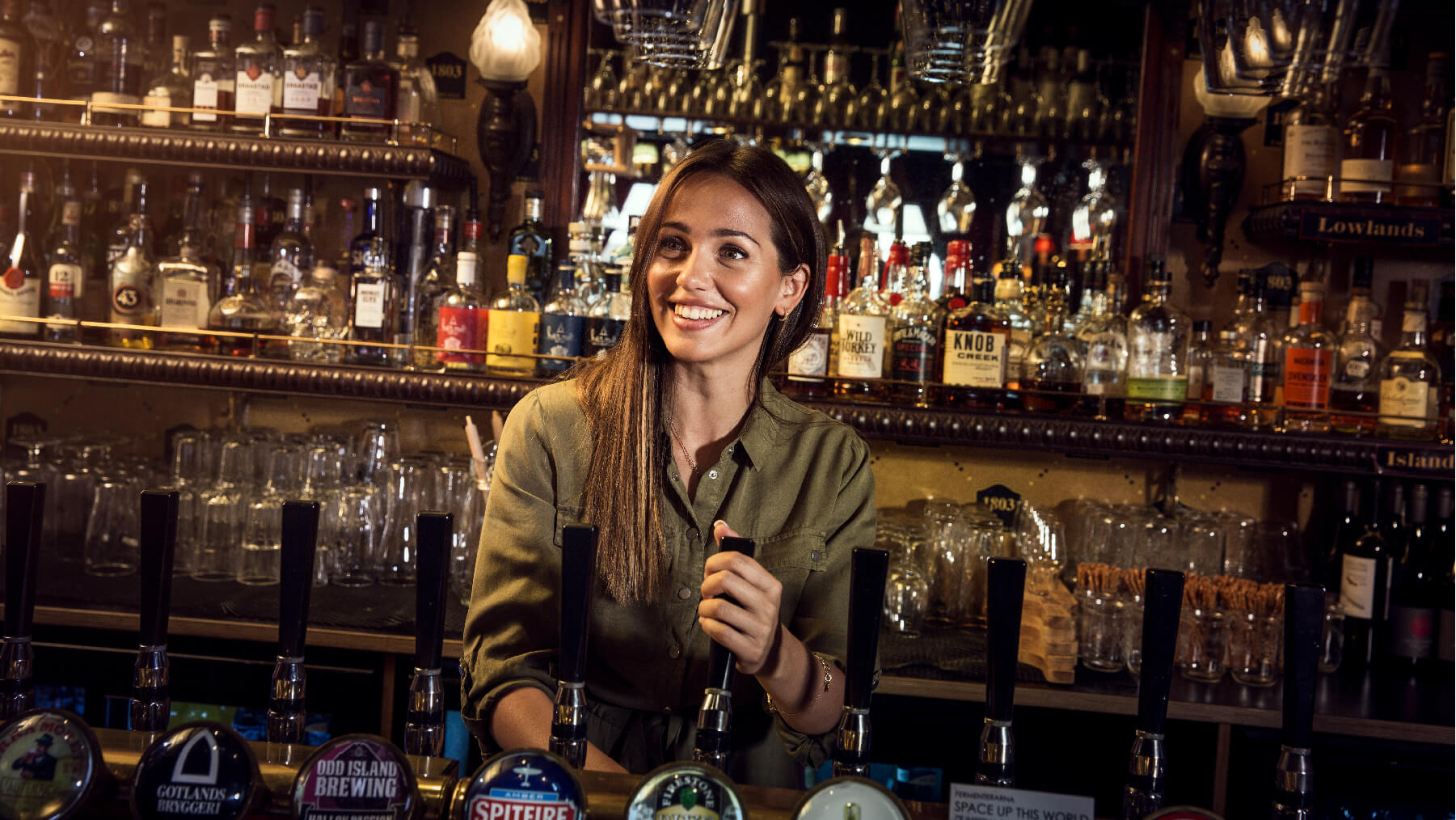 Foto på Jeny Meira som häller upp öl bakom en bardisk
