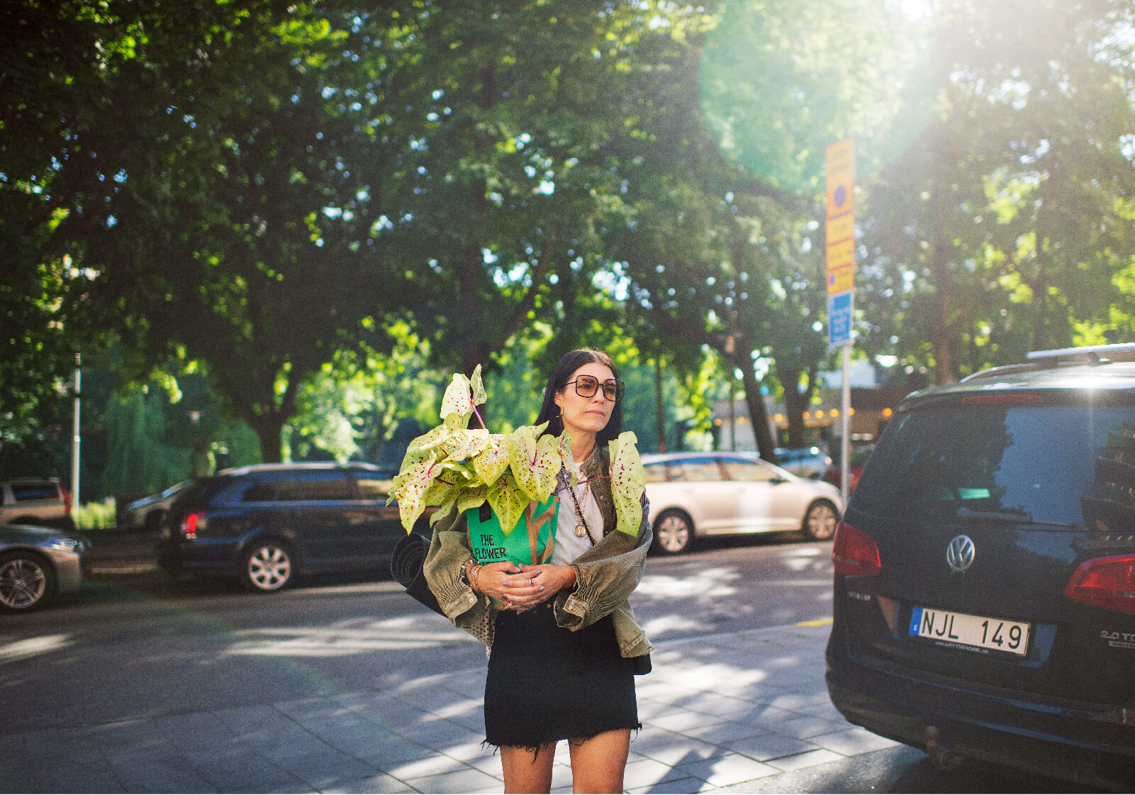 Nina Lindvall står på en gartan med en påse med en stor blomma i famnen.