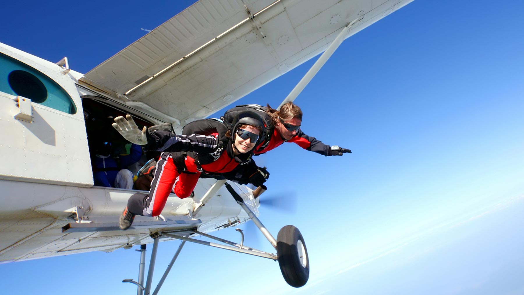 Två personer som hoppar fallskärm - eller precis ska hoppa