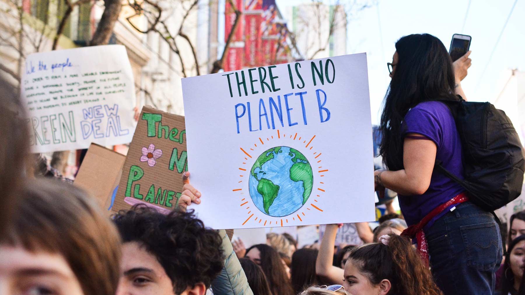 En demonstration med många ungdomar. En person håller upp en skylt med texten" Det finns ingen planet B" på engelska..