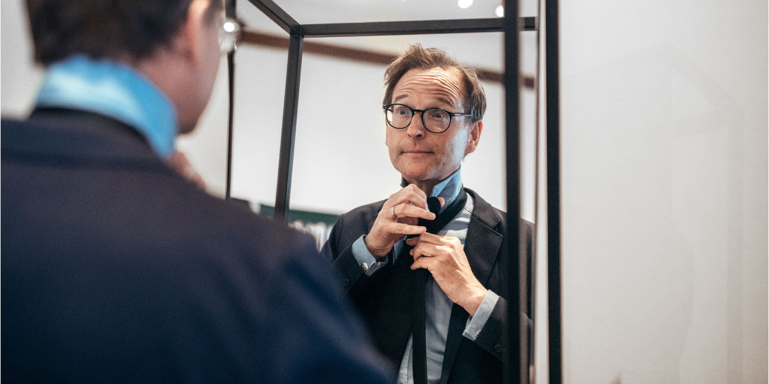 Lars Strannegård knyter sin slips framför en spegel.